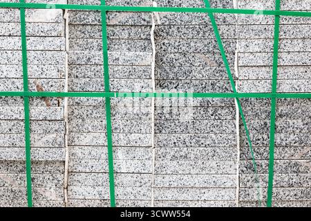 Packs of new paving granite tiles stacked on pallets for laying on the road Stock Photo