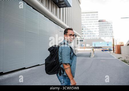 Handsome man with tattoos walking down the street. Stock Photo