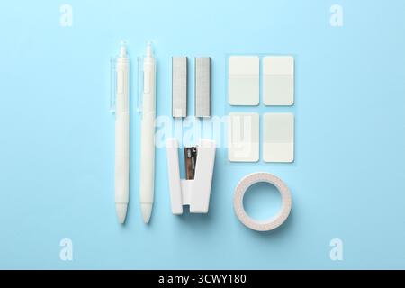 Stapler and other stationery on light blue background, flat lay Stock Photo