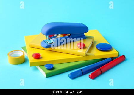 Stapler and other stationery on light blue background Stock Photo