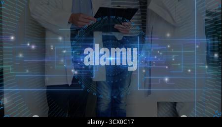 Three professionals wearing lab coats analyzing holographic interface in lab, with tablet device Stock Photo