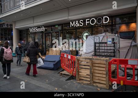 Homeless shelter built outside the entrance to a Marks & Spencer Food, local grocery and food store located on Tottenham Court Road, central London UK Stock Photo