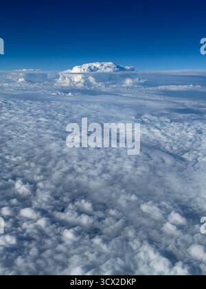 View from an airplane window looking down on the clouds Stock Photo