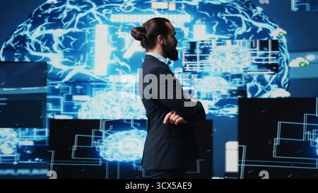 Male entrepreneur works on implementing AI brain system for deep learning, employing neural networks and cybernetics for growth. Using smart technology and algorithmic thinking. Camera B. Stock Photo