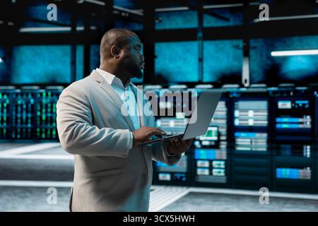 Data center admin running system diagnostic tests and error checking utilities to identify and resolve problems. IT expert looking for network issues affecting server performance and connectivity Stock Photo