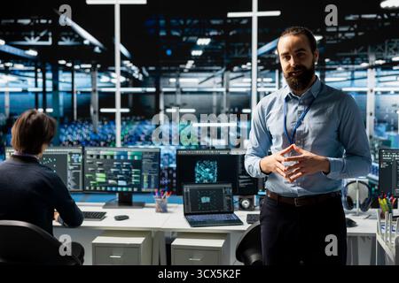 Data center manager presents AI tech to shareholders, demonstrating predictive maintenance capabilities. Man briefing investors on server farm artificial intelligence infrastructure Stock Photo