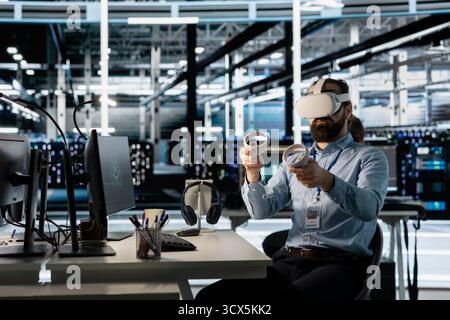 Technician using VR headset in data center to update server tech, configuring equipment using software tools. Server room employee reviewing hardware analytics using virtual reality Stock Photo