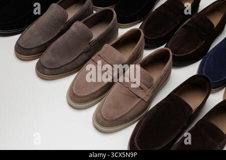 Array of suede mens loafers in assorted colors on a clean studio background, perfect for fashion retail, catalog, and online store banners. Stock Photo