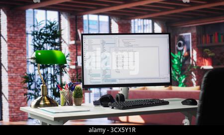 Empty desktop monitor used for software development and coding in a luxurious loft apartment. Modern workstation or in a stylish studio supports tech performance and big data systems. Stock Photo