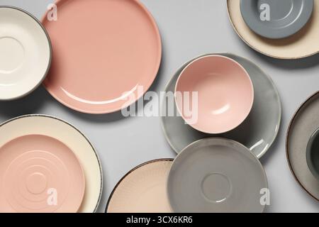 Set of clean plates and bowls on grey background Stock Photo