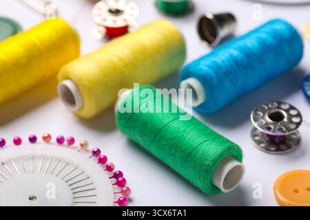 Composition with different thread spools and ball pins on white background, closeup Stock Photo