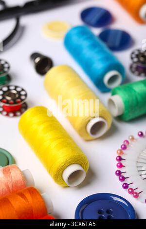 Composition with different thread spools and accessories on white background, closeup Stock Photo