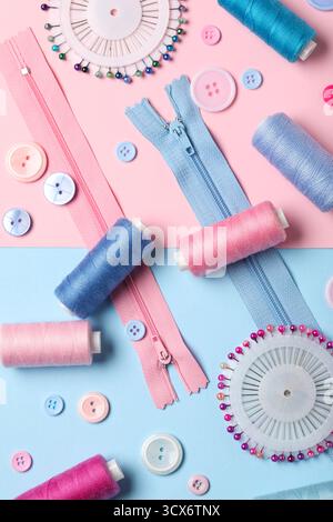 Composition with thread spools, zippers, ball pins and buttons on color background, closeup Stock Photo