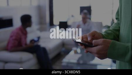 Checking smartphone, Korean man at home, friends gaming on sofa with controller, copy space Stock Photo