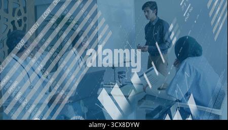 Standing presenter writing on whiteboard in office, team using laptops, data overlays, copy space Stock Photo
