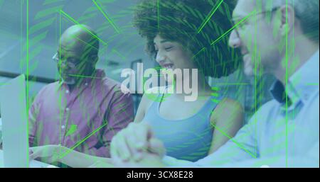 Collaborating team members analyzing data at modern office desk, with laptop and AR overlay Stock Photo