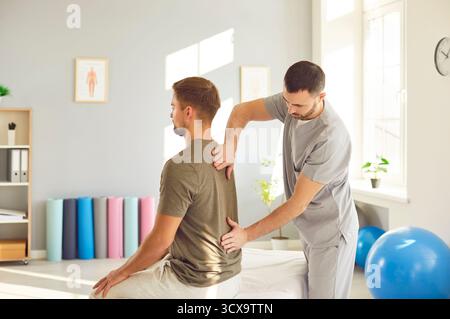 Physiotherapist consulting patient in rehabilitation center after traumatic injury Stock Photo