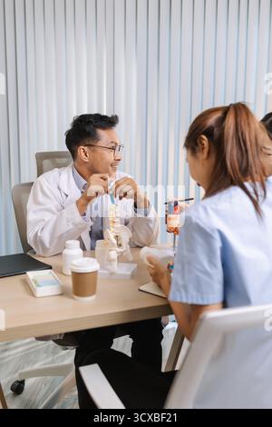 Team of doctors and nurses collaborating in a clinical environment, reviewing treatment options and sharing medical opinions to provide effective pati Stock Photo