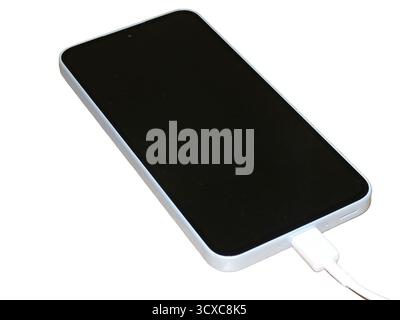 Smartphone isolated on white background. A smartphone is charging Stock Photo