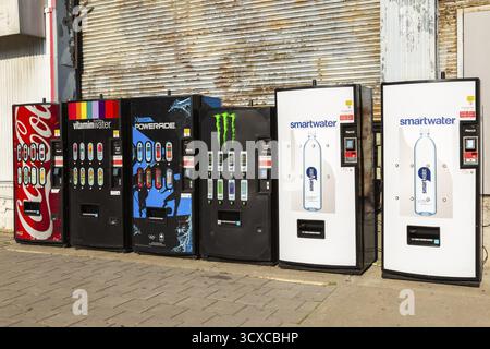 Row of popular bottled cold soft drinks and mineral water brands for sell in vending machines on promenade in Old Port of Montreal, Quebec, Canada Stock Photo