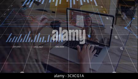 Woman holding coffee mug, typing on laptop at home office table with financial charts during call Stock Photo
