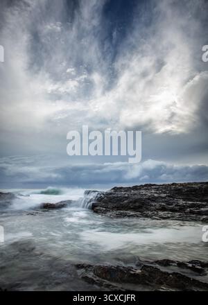 Rough seas crash against the rocky coast of Snapper Rocks, located on the Gold Coast, Queensland, Australia. Stock Photo