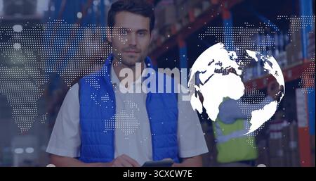 Checking stock, manager in blue vest with tablet in warehouse racks, boxes, digital map overlay Stock Photo