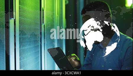 IT technician monitoring servers in LED server corridor, with tablet and globe overlay, copy space Stock Photo
