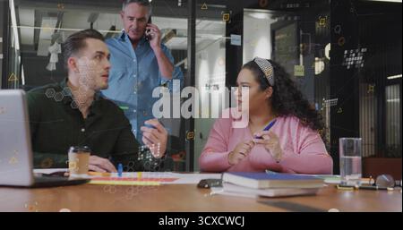 Discussing project details three professionals collaborating at conference table, with laptop pens Stock Photo