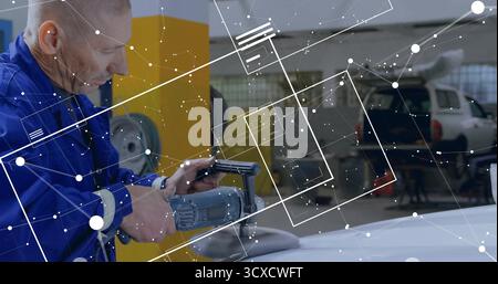 Buffing mechanic in coverall using buffer on white hood in shop with digital graphics, copy space Stock Photo
