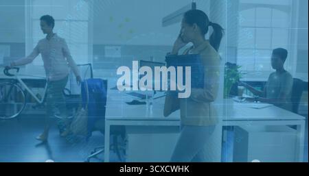 Talking Korean woman holding black folder and speaking on smartphone in office with white bicycle Stock Photo