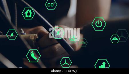 Gripping electrical cables and connectors inside control panel, displaying green hex energy icons Stock Photo