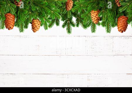 Fir Branches and Pine Cones Border on White Wood Stock Photo