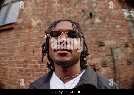 Portrait of Young Adult Black Man with Dreadlocks Wearing Sunglasses Smiling Stock Photo