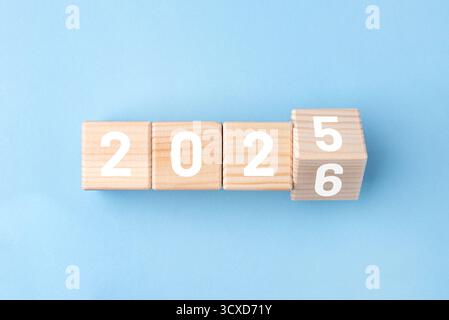 Wooden cubes with alternating numbers of 2026 on the blue background Stock Photo