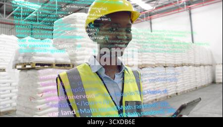 Warehouse inspector wearing safety vest scanning pallets with AR code overlay in aisle, with tablet Stock Photo
