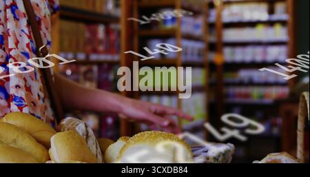 Pointing floral-dress shopper toward bread in wicker baskets on bakery display with grocery shelves Stock Photo
