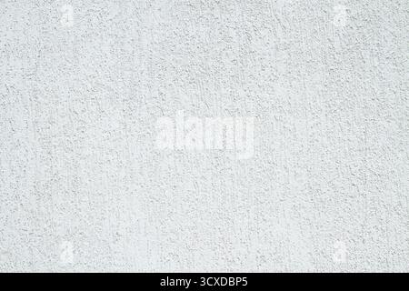Grey cement plaster background. Backdrop formed by light plaster near an old house on a sunny day. White plaster background Stock Photo