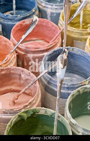 Group of open cans of multi-coloured paints, close-up shot, abstract artistic background Stock Photo