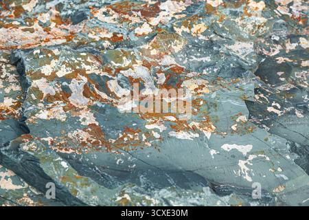 The texture of natural stone with an uneven surface and multi-colored inclusions Stock Photo