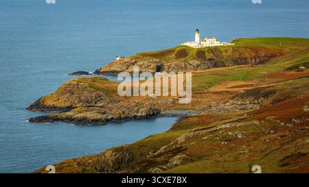 Aerial view of a lighthouse on a rocky cliff overlooking the ocean ...