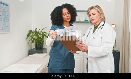 Professional Doctor Consultation Between Two Medical Professionals in Clinic Setting Stock Photo