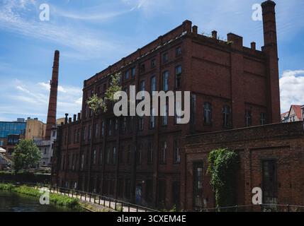 An old abandoned brick building overgrown with plants Stock Photo