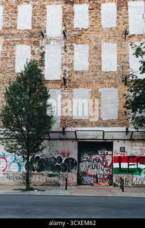 A fragment of a brick wall with bricked-up windows and painted white Stock Photo
