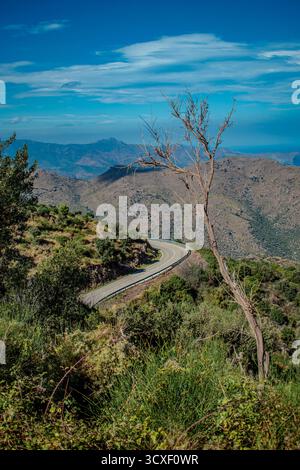 A serpentine road meandering through the rugged mountains of Spain, surrounded by breathtaking views and wild nature. Stock Photo