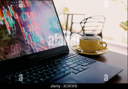 Laptop Displaying Bitcoin Cryptocurrency Coins with European Union Flag Background and Coffee Cup on Table Stock Photo