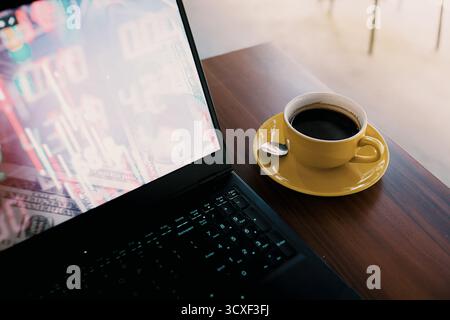 Laptop Displaying Bitcoin Cryptocurrency Coins with European Union Flag Background and Coffee Cup on Table Stock Photo