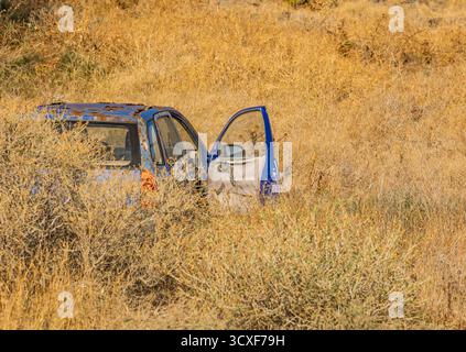 abandoned car in a golden field Stock Photo