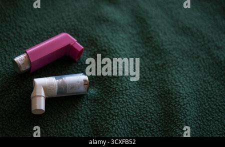 Two asthma inhalers with a white background lying next to each other ...