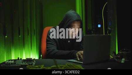 Testing engineer repairing circuit board in server room with laptop, network cables Stock Photo